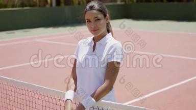 微笑的年轻女子在网球场上<strong>捧</strong>场